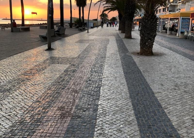 Algarve promenade with palm trees at sunset