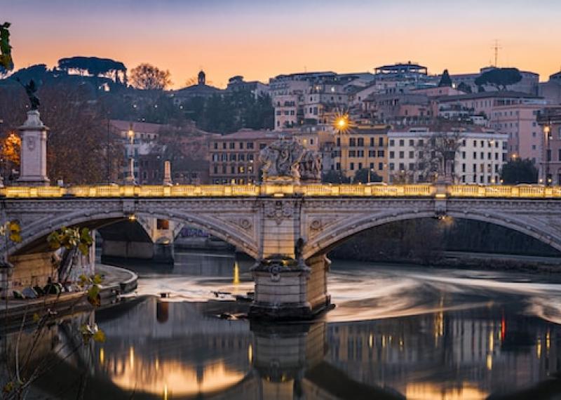 Rome view on River Tiber with bridge and buildings in the background