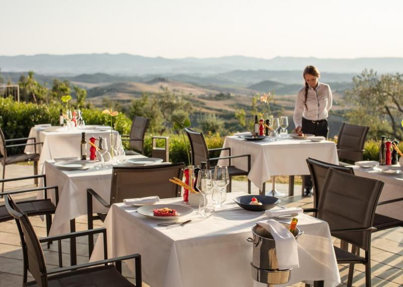 Ristorante al Castelfalfi con cameriera e tavoli apparecchiati