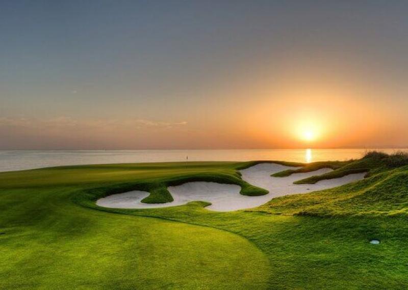 Al Mouj Golf fairway and bunkers view at sunset