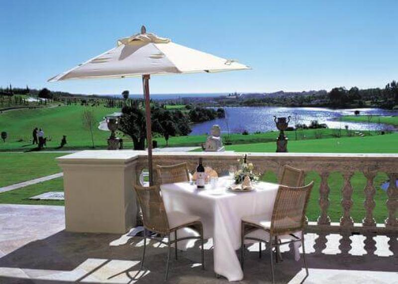 Anantara Villa Padierna Palace restaurant with set table and umbrella overlooking the course