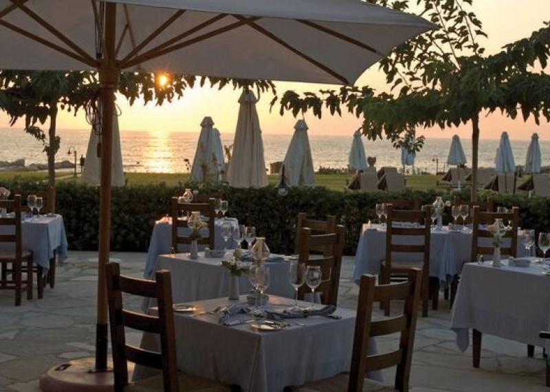 Sea view hotel restaurant with set tables and umbrellas