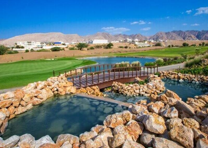 Ghala Golf Club course view with water obstacles and wooden bridge