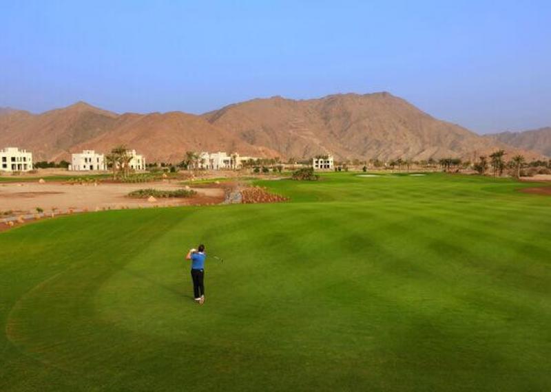 Jebel Sifah Golf Course vista fairway e montagne rosse