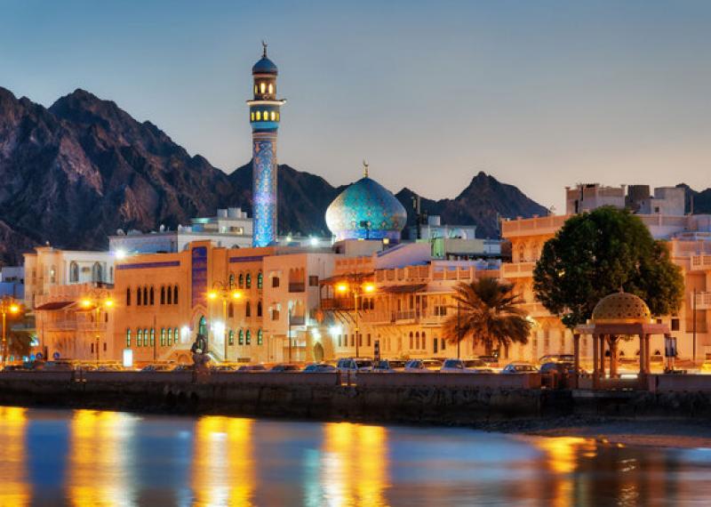 Muscat by night with lights and reflections on the sea