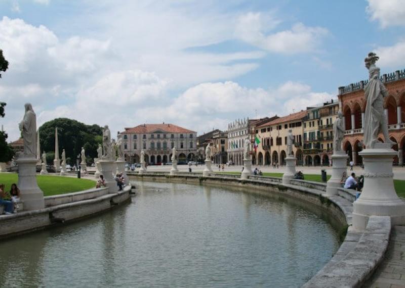 Naviglio curvo a Padova con statue e palazzi intorno