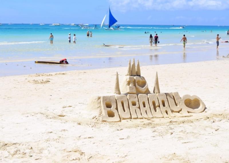 Boracay beach with sand sculpture and turquoise sea in the background