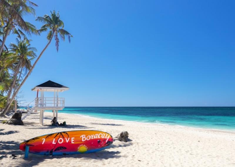 Boracay beach with turquoise sea and surfboard